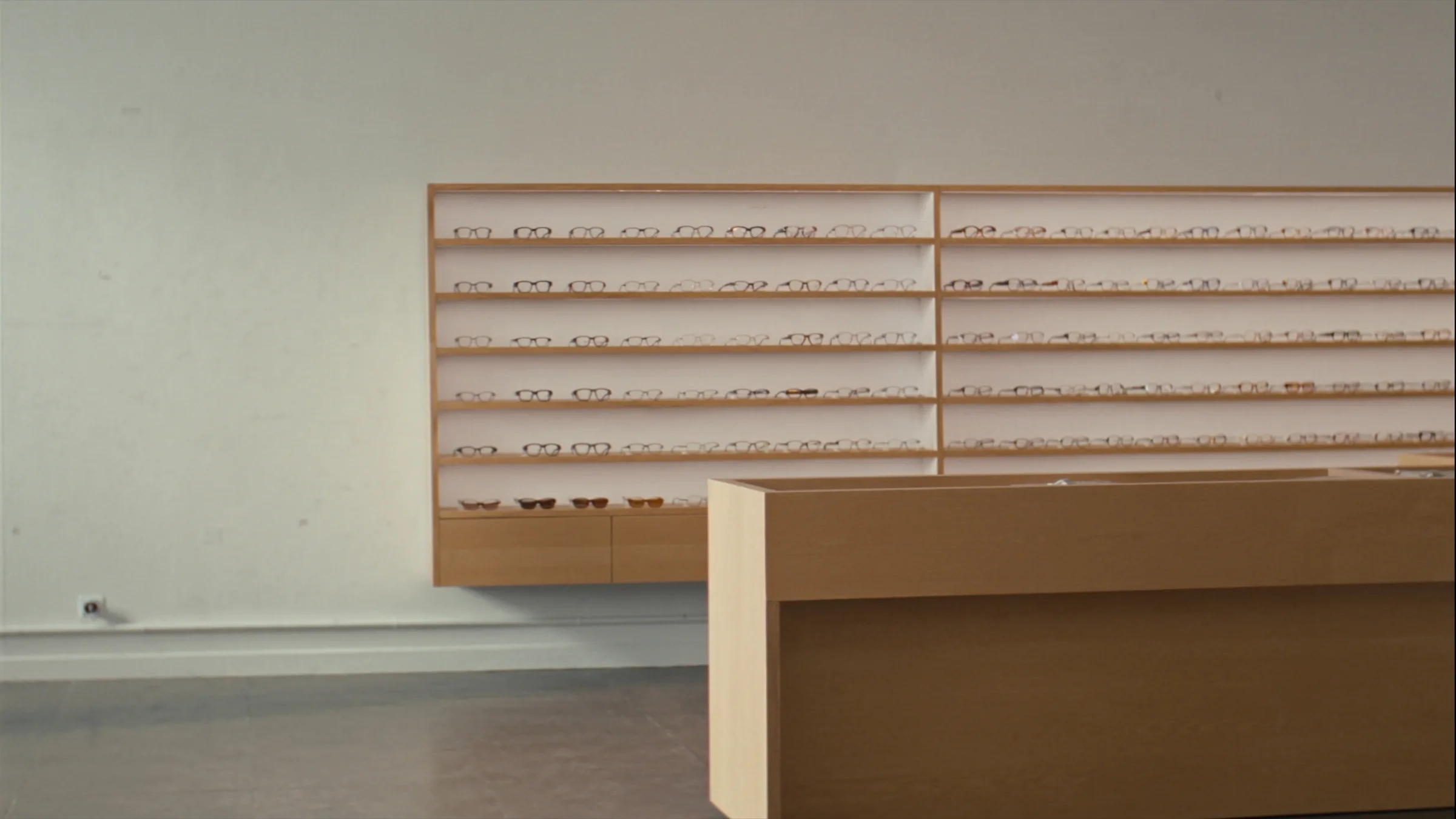 Optometrist marketing, optometry boutique, pale oak shelving displaying eyewear frames