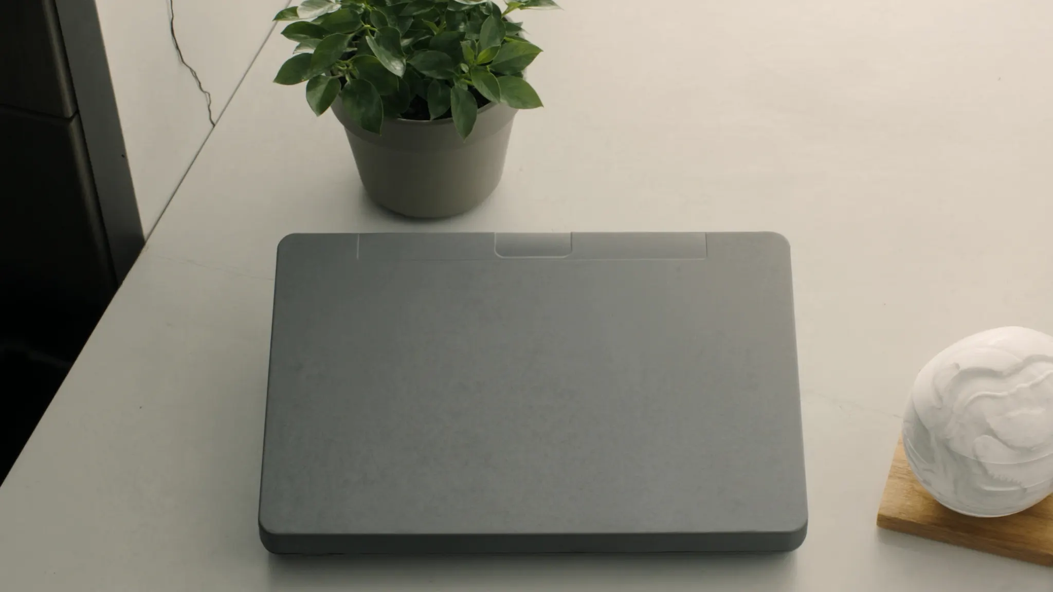 AI integrations, desk with a closed laptop and a sculptural orb