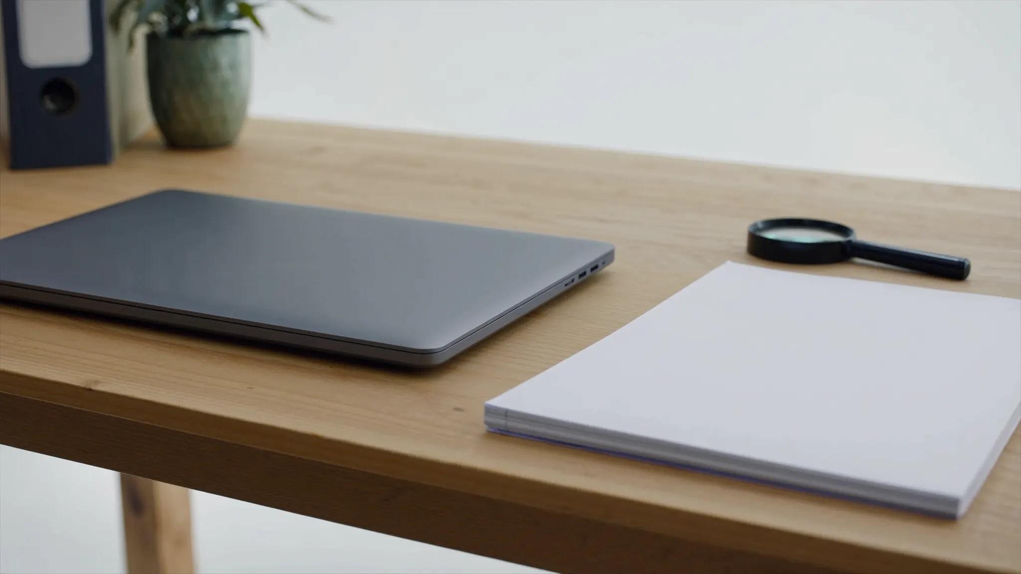 Questions et réponses sur Google Maps, bureau clair avec un carnet fermé et une loupe posée à plat